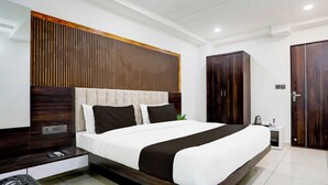 A modern bedroom with a large bed, wooden headboard, and a wardrobe. - Collection Ransan Circle Nana Chiloda (Gandhinagar)