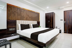 A modern bedroom with a large bed, wooden headboard, and a wardrobe. - Collection Ransan Circle Nana Chiloda (Gandhinagar)
