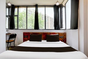 A hotel room with a large bed, two pillows, a desk with a chair, and a window with curtains. - Collection O Bhopal DB City Mall (Bhopal)