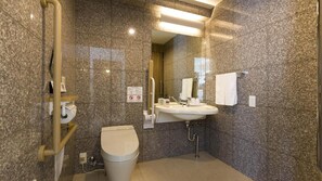 Casa de banho moderna com paredes de granito, uma sanita e uma pia branca.
