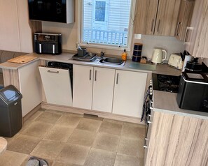 Eine kleine Küche mit Geschirrspüler, Kaffeemaschine und Toaster.