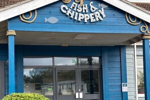 Ein blaues Ladenlokal mit einem Schild, das 'Fish & Chipspery' zeigt, und einem Fischsymbol.