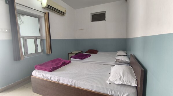A hotel room with a bed, a nightstand, and a window.