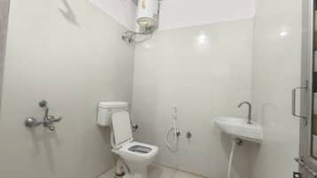 Un baño con inodoro, lavamanos y ducha.
