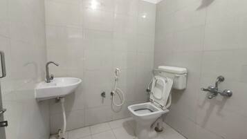 A small, clean bathroom with a white sink, toilet, and shower.