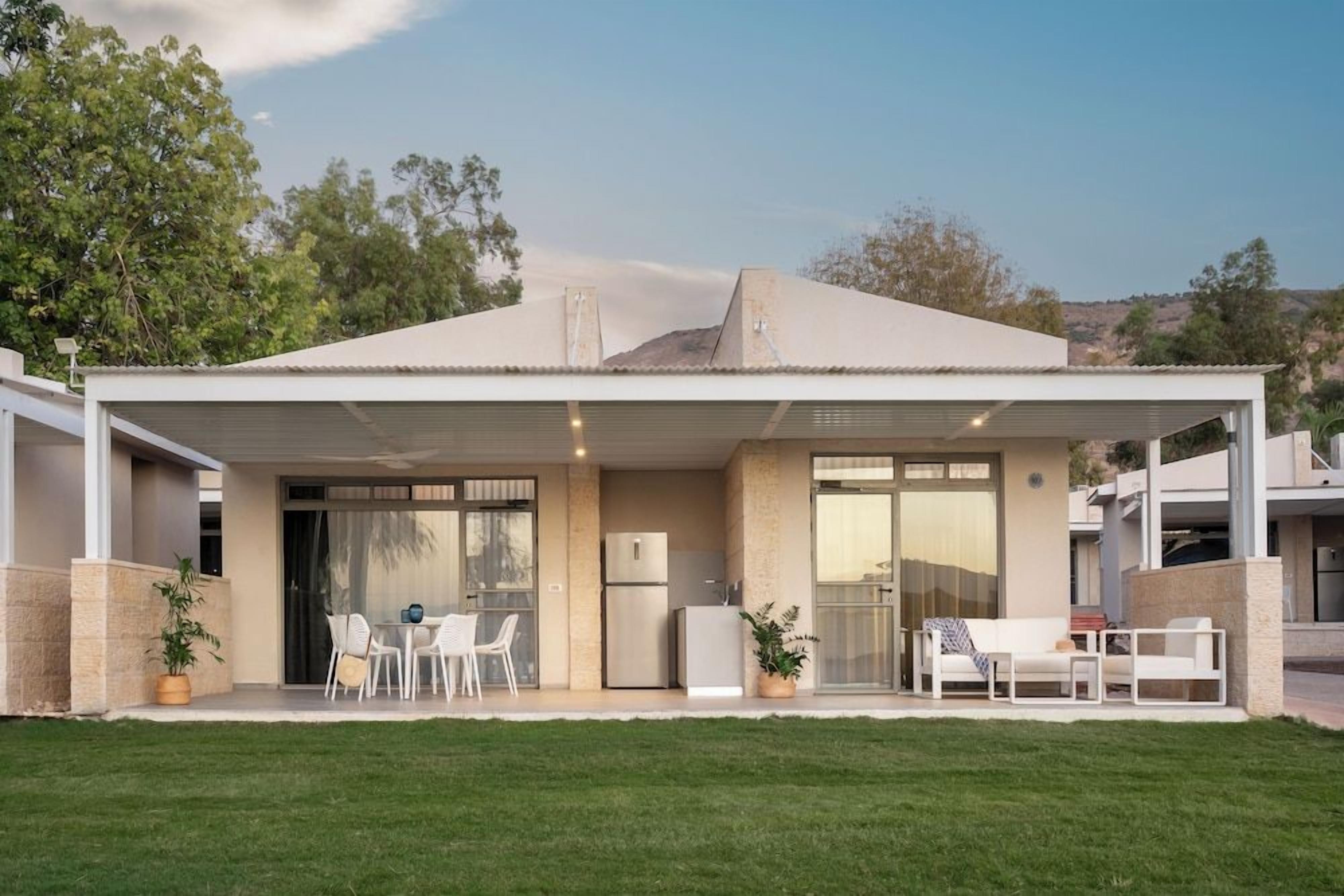 A modern house with a covered patio, a kitchen, and a dining area.