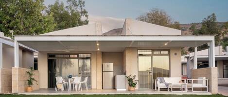 A modern house with a covered patio, a kitchen, and a dining area.