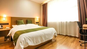 A hotel room with a large bed, bedside tables, a desk, and a window with curtains. - Greentree Inn Express Xuzhou Pizhou Tiefu Town Bus Station (Xuzhou)