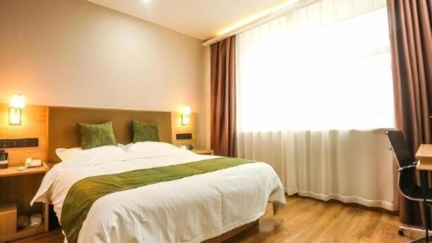 A hotel room with a bed, bedside tables, a desk, and a window with curtains. - Greentree Inn Express Xuzhou Pizhou Tiefu Town Bus Station (Xuzhou)