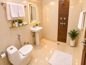 A modern bathroom with a toilet, sink, shower, and a mirror with lights. - HOTEL GLOBAL REDIANCE DELHI AIRPORT  (New Delhi)
