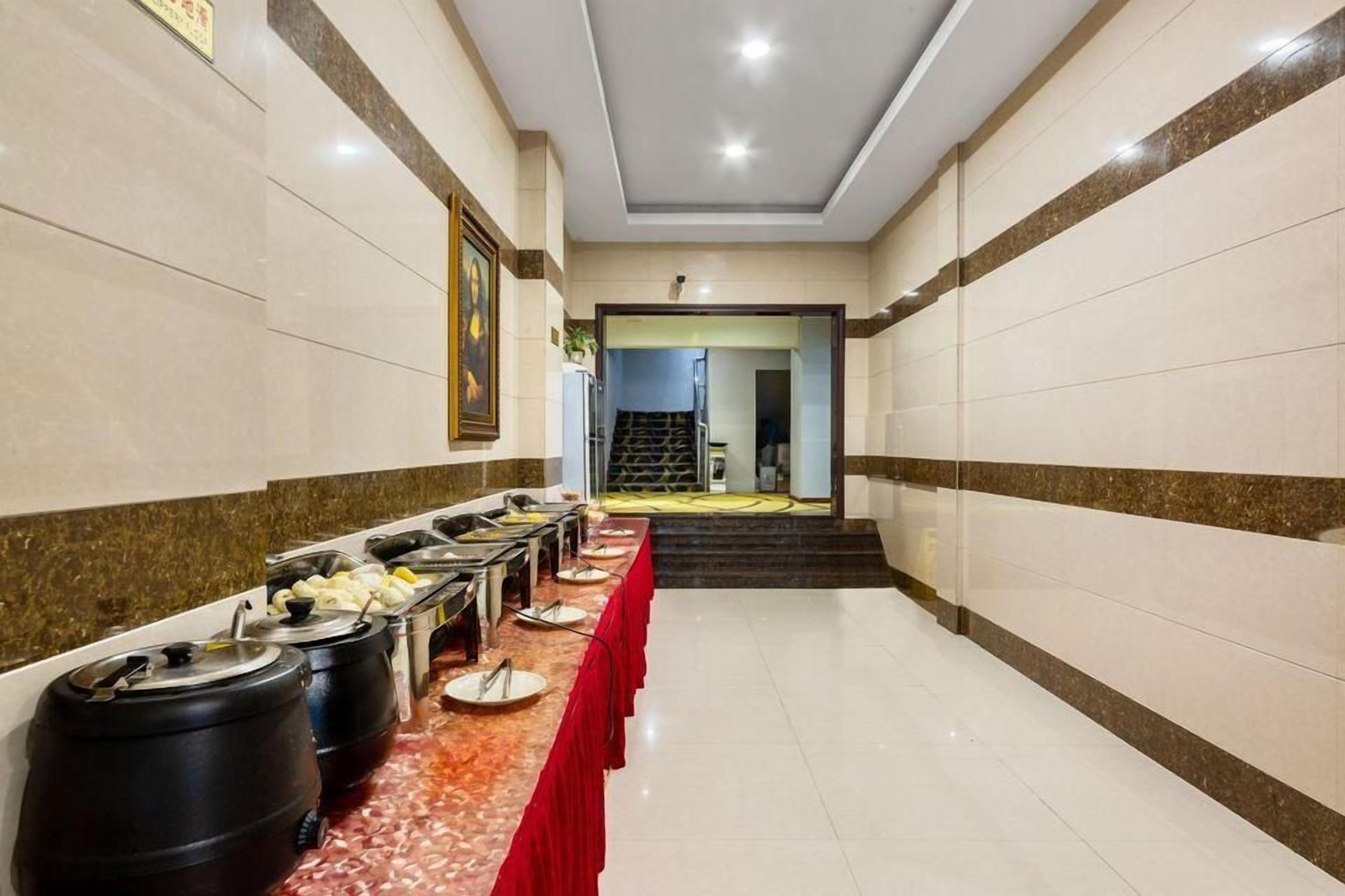 A buffet setup with multiple food stations and a red tablecloth.