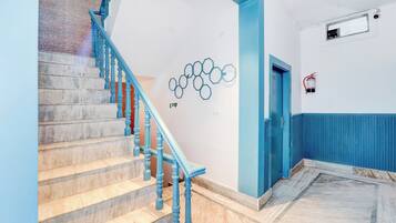 Una escalera con barandas azules que lleva a un rellano.