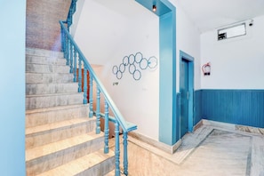 Una escalera con barandas azules que lleva a un rellano.