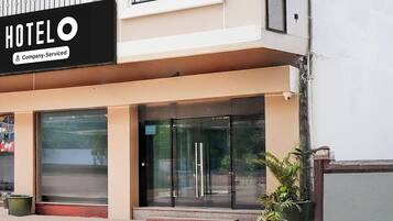 Entrada de hotel con puerta de vidrio y un letrero que dice 'HOTEL'.
