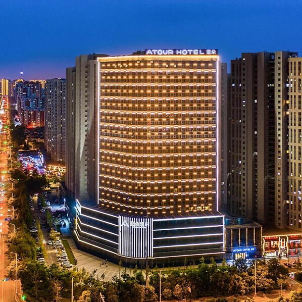 A multi-story hotel with a prominent sign at the top. - Beijing Road Atour Hotel (Linyi)