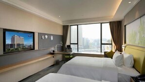 A hotel room with two beds, a desk, a chair, a TV, and a large window with a city view. - Hampton by Hilton (Guangzhou)