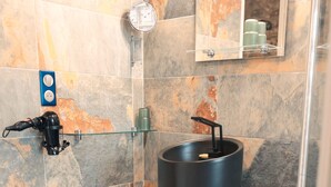 A modern bathroom with a shower, a glass sink, and a mirror. - Vrbo Property (Limoux)