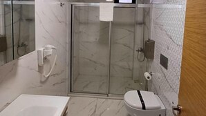 Un baño con ducha, inodoro y lavabo.