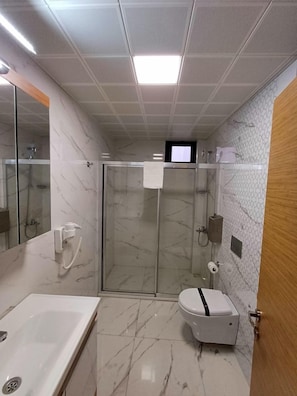 Un baño con ducha, inodoro y lavabo.