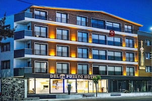 Un hotel de varios pisos con un cartel que dice 'Del Puerto Hotel'.