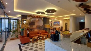 Un vestíbulo moderno de hotel con una zona de estar, una recepción y un ventanal grande.