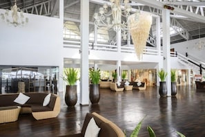 A spacious lobby with high ceilings, a grand chandelier, and multiple seating areas. - VOI Andilana Beach Resort (Nosy Be)