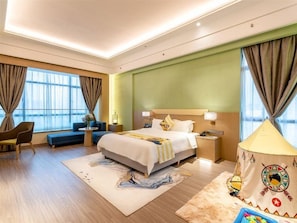 Une chambre d’hôtel avec un grand lit, un canapé, un bureau et une lampe.