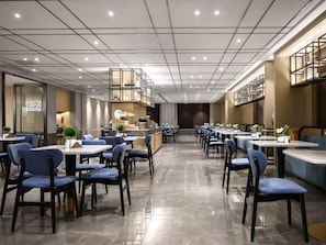 Un restaurant spacieux avec de hauts plafonds et un éclairage moderne.