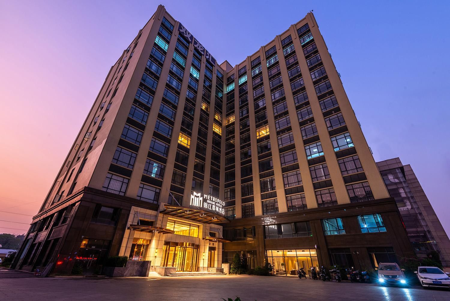 A high-rise hotel with multiple floors, a prominent entrance, and a well-lit facade.