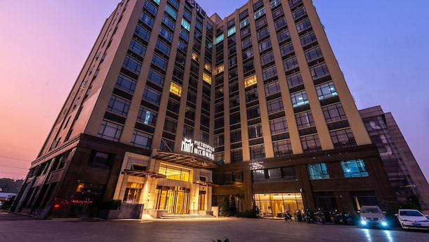 Et højt hotel med flere etager, en markant indgang og en veloplyst facade.