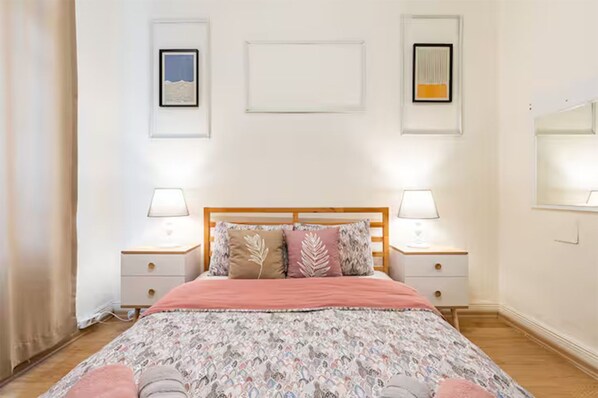 Una camera da letto con un letto, due comodini e lampade a parete.
