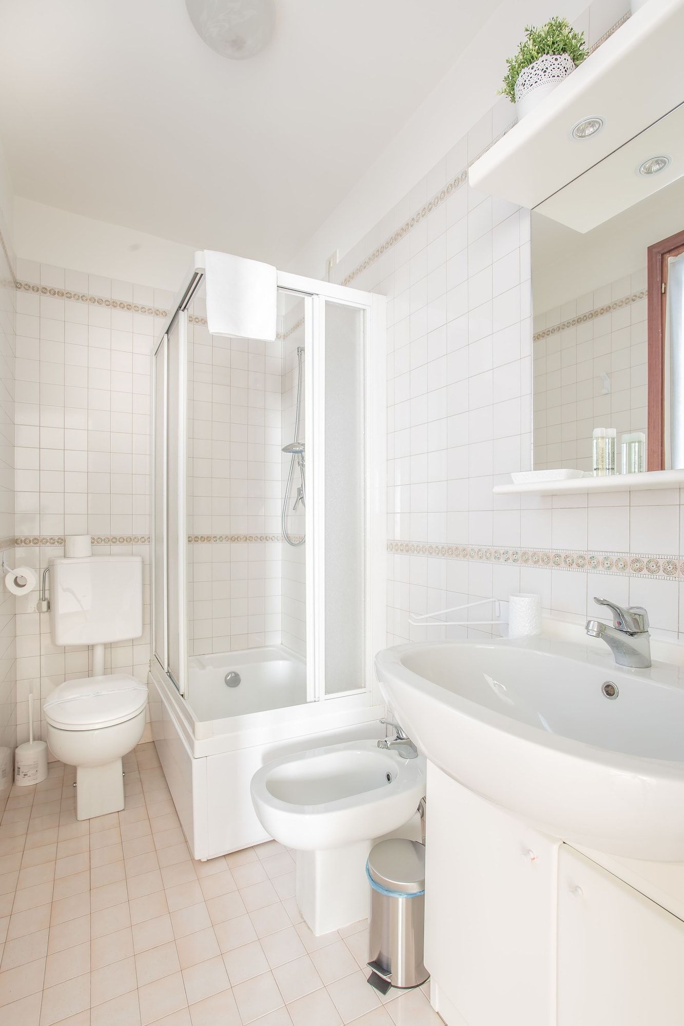 Un baño moderno con inodoro, bidé, ducha y lavamanos.