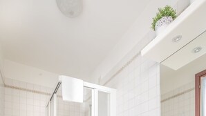 Ein modernes Badezimmer mit Toilette, Bidet, Dusche und Waschbecken.