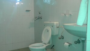 Een badkamer met toilet, wastafel en douche.