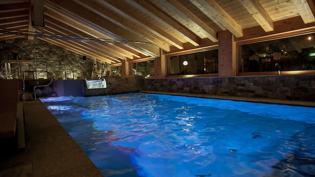 Ein Hallenbad mit Steinwänden und Holzbalken.