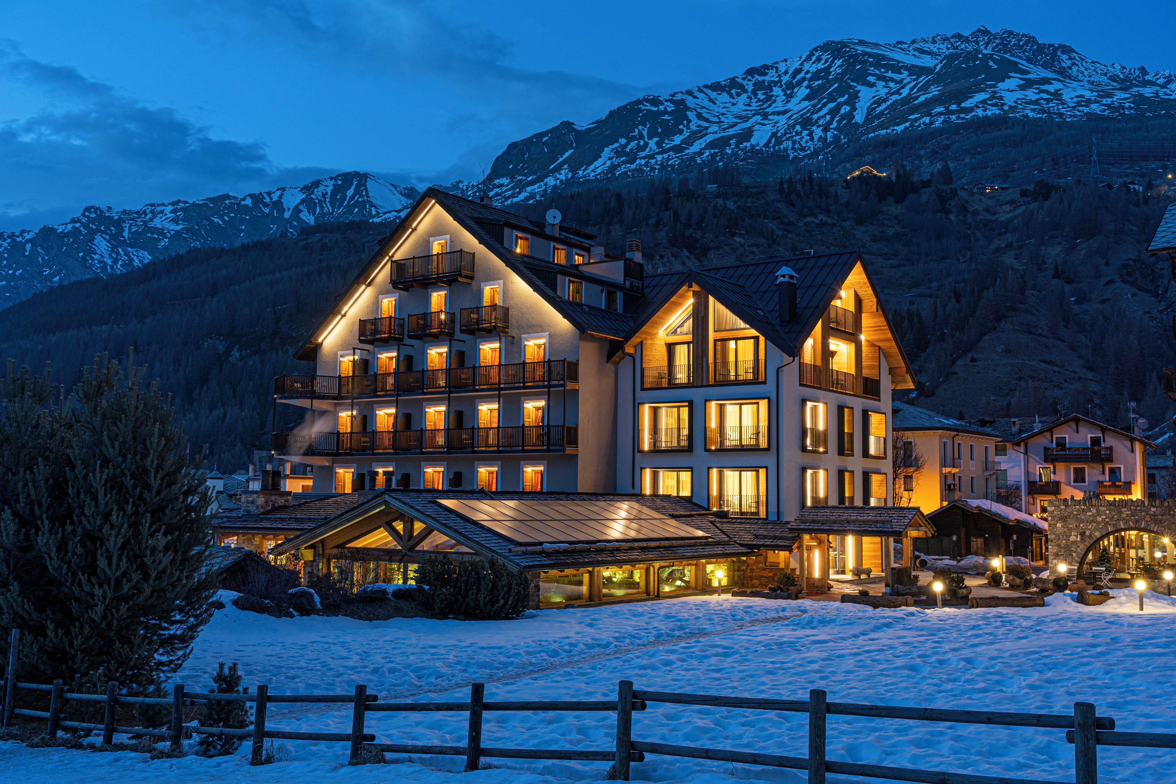 Un hôtel à plusieurs étages, doté de balcons, qui offre une vue sur un paysage enneigé.