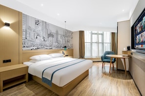 A modern hotel room with a large bed, a desk, a chair, and a cityscape mural on the wall. - City Comfort Inn Changzhou Global Harbor Dinosaur Park (Changzhou)