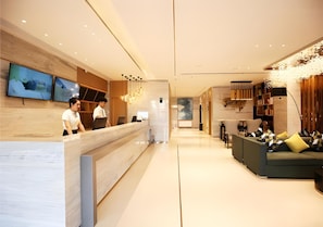 A hotel lobby with a reception desk, seating area, and artwork on the walls. - City Comfort Inn Changzhou Global Harbor Dinosaur Park (Changzhou)