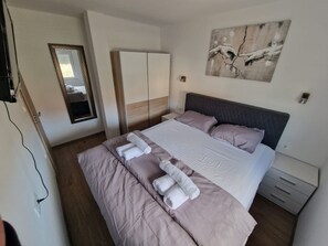 A hotel room with a bed, a wardrobe, a mirror, and a painting on the wall. - Beautiful apartment Antonio with balcony, close to the beach (Kaštel Novi)