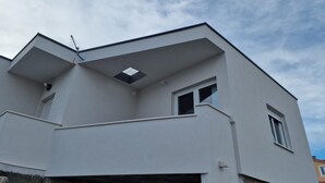 Ein modernes Gebäude mit Flachdach, kleinem Fenster und sichtbarer Antenne.
