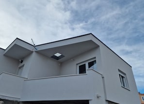 Un edificio moderno con techo plano, una ventana pequeña y una antena visible.