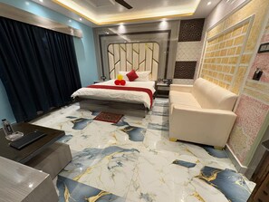 Una habitación de hotel con cama, sofá, escritorio y piso estampado.