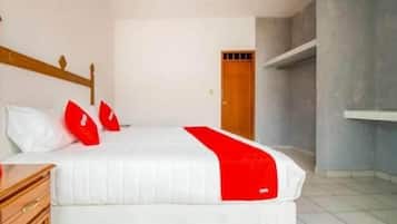 Habitación con cama individual, cabecera de madera, colchón blanco y detalles en rojo.