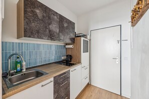 A compact kitchen with a sink, countertop, and cabinets. - Centrally Located Apartment in Passau | Washer, Dryer, Wi-Fi, and Pets Welcome (Passau)