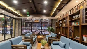 Um interior moderno com assentos, mesa de centro e estantes.
