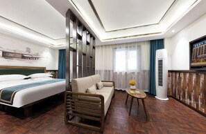 A hotel room with a bed, sofa, small table, and a wall-mounted TV. - Time Walk Hotel (Taiyuan)