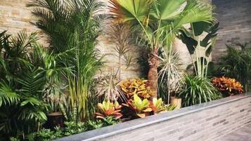 A landscaped area with various plants and a brick wall.
