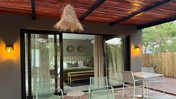 A modern bedroom with a bed, a bench, and a table. - Together Lifestyle Resort (Thulamela)