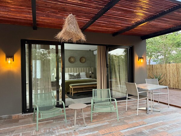 A modern bedroom with a bed, a bench, and a table. - Together Lifestyle Resort (Thulamela)