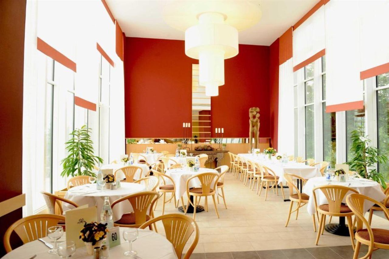 Ein Restaurant mit runden Tischen, Stühlen und einem zentralen Dekorationselement.